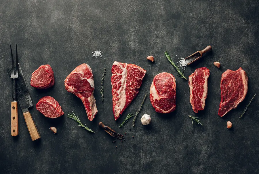 Raw beef cuts arranged on a wooden board