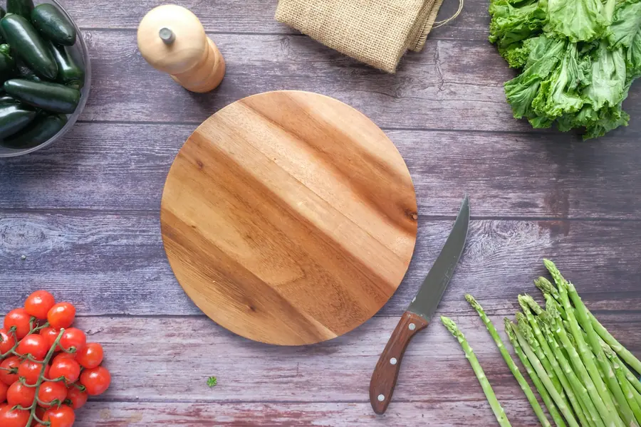 A chopping board with a knife and vegetables