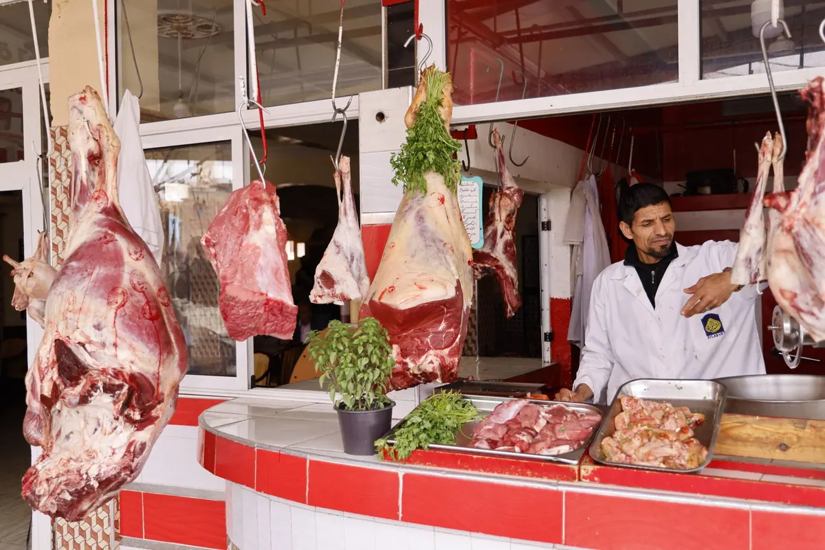 A butcher serving a customer