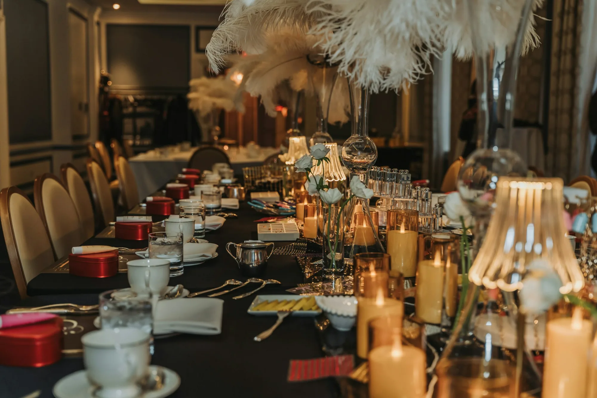 A long table set for a gathering, lit by candles