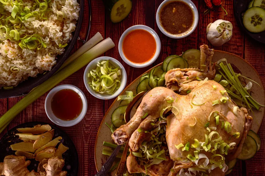 A platter of chicken and rice with sauce