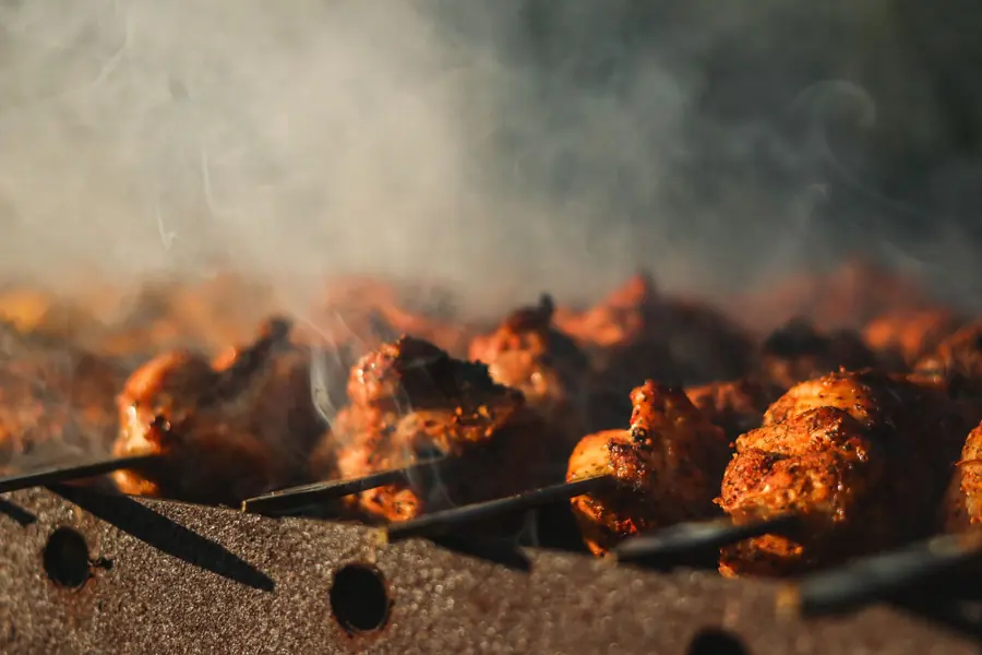 Charred chicken skewers on a grill