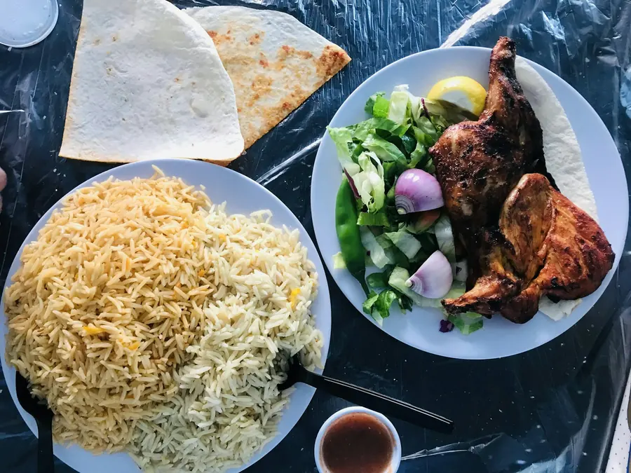 A dinner plate with meat, rice and salad