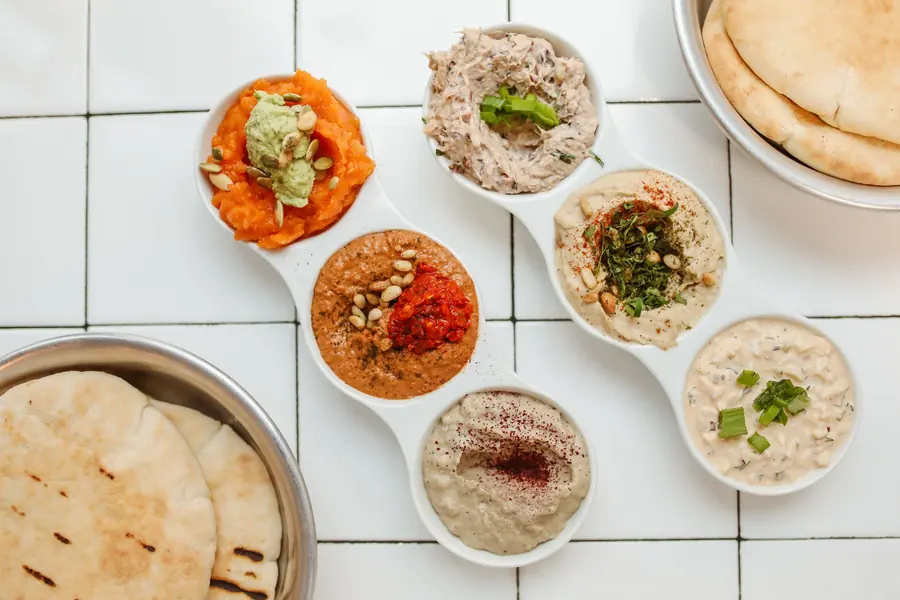 A platter of assorted dips served with warm pita for sharing