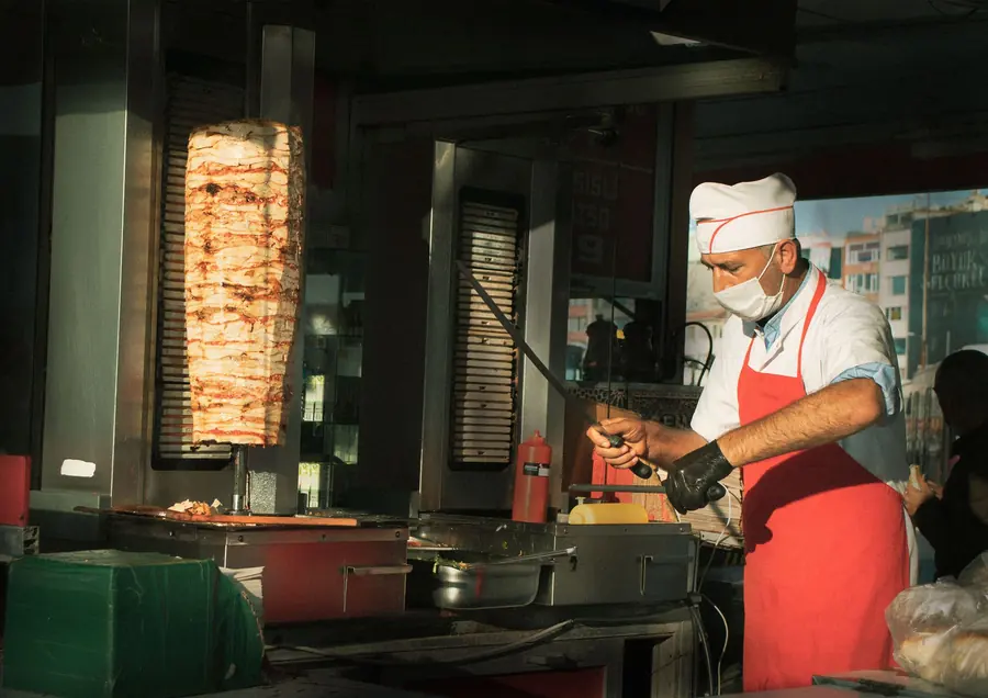 Thin slices being carved from a rotating cone of meat