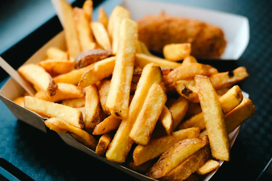 A fast food tray with fries and a drink