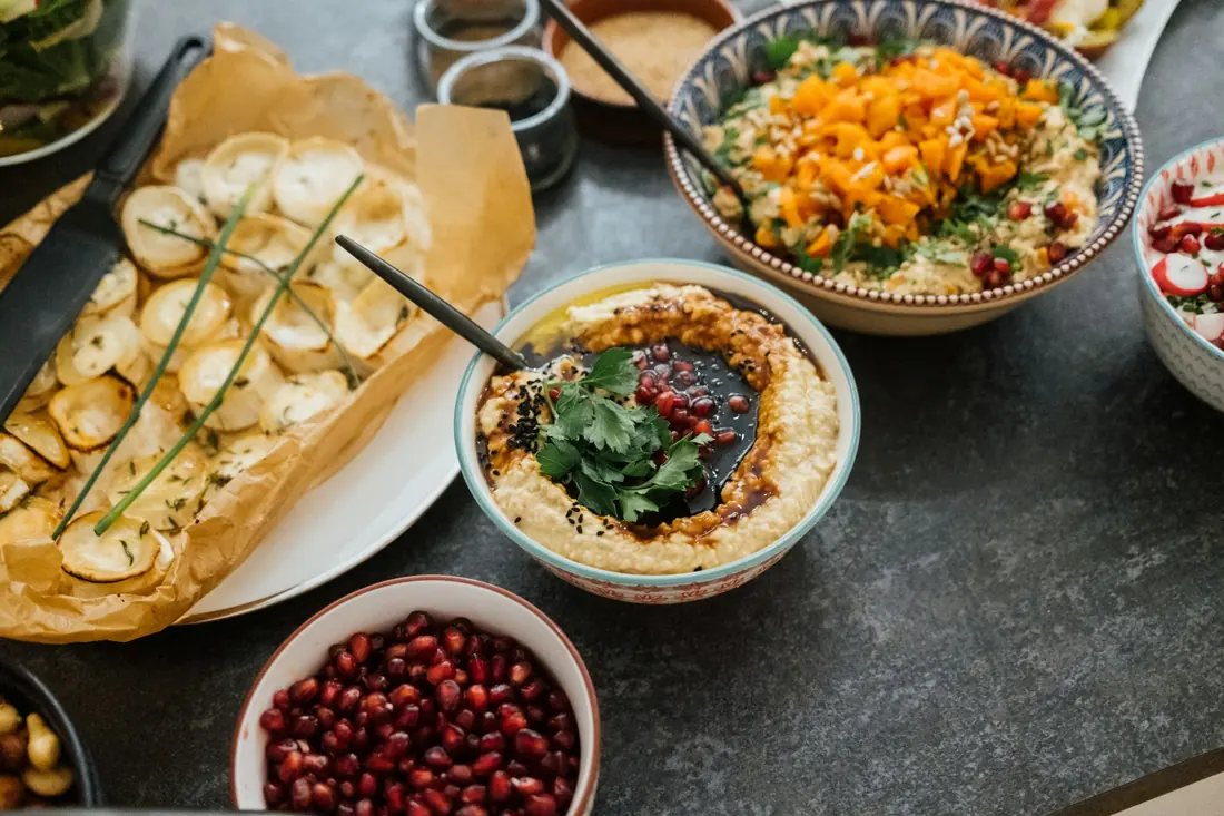 Mezze spread of hummus, dips, flatbread and pomegranate seeds