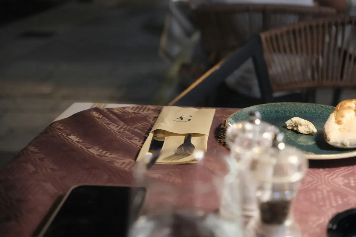 A table of Greek dishes including salad, dips and grilled meat