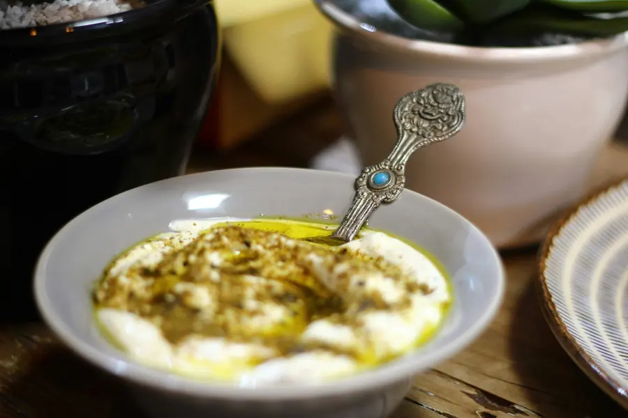 A bowl of thick yogurt dip drizzled with olive oil