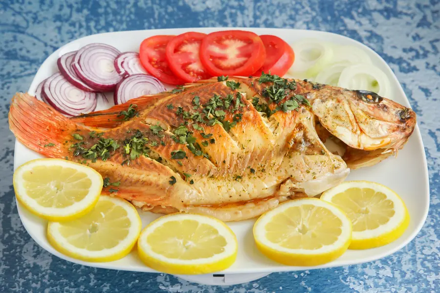 A grilled whole fish served with lemon