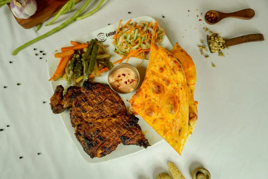 A platter of grilled meat served with rice and bread
