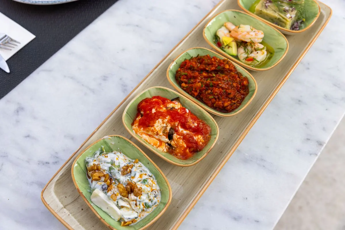 A spread of Mediterranean small plates including dips, salads and flatbread