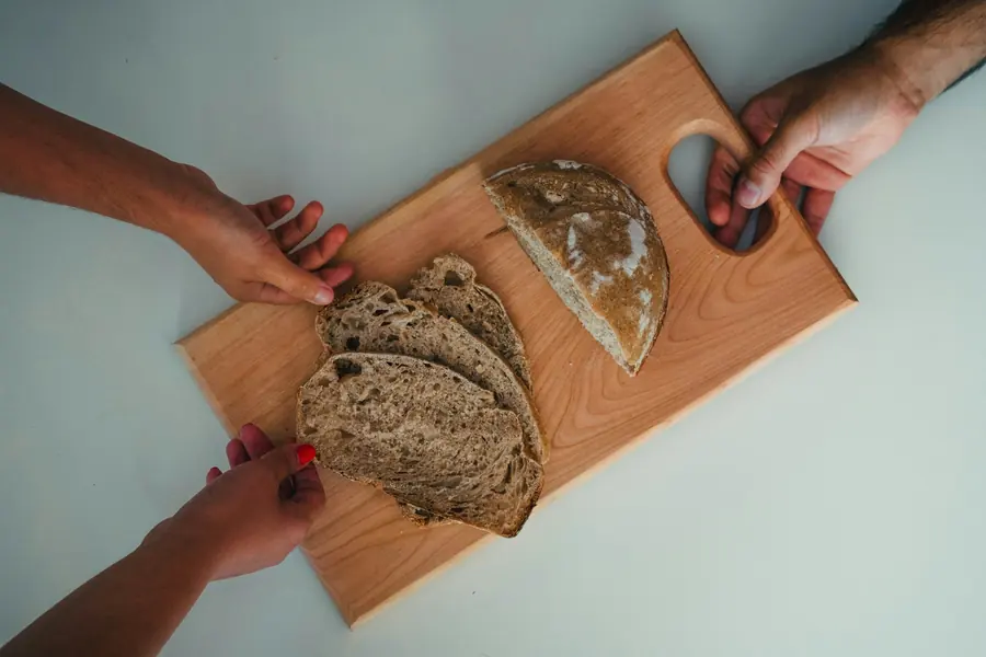 Hands tearing a piece of bread