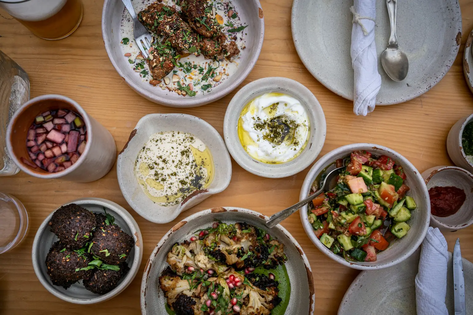 Mediterranean table spread with kofta, hummus, fresh salads and dips