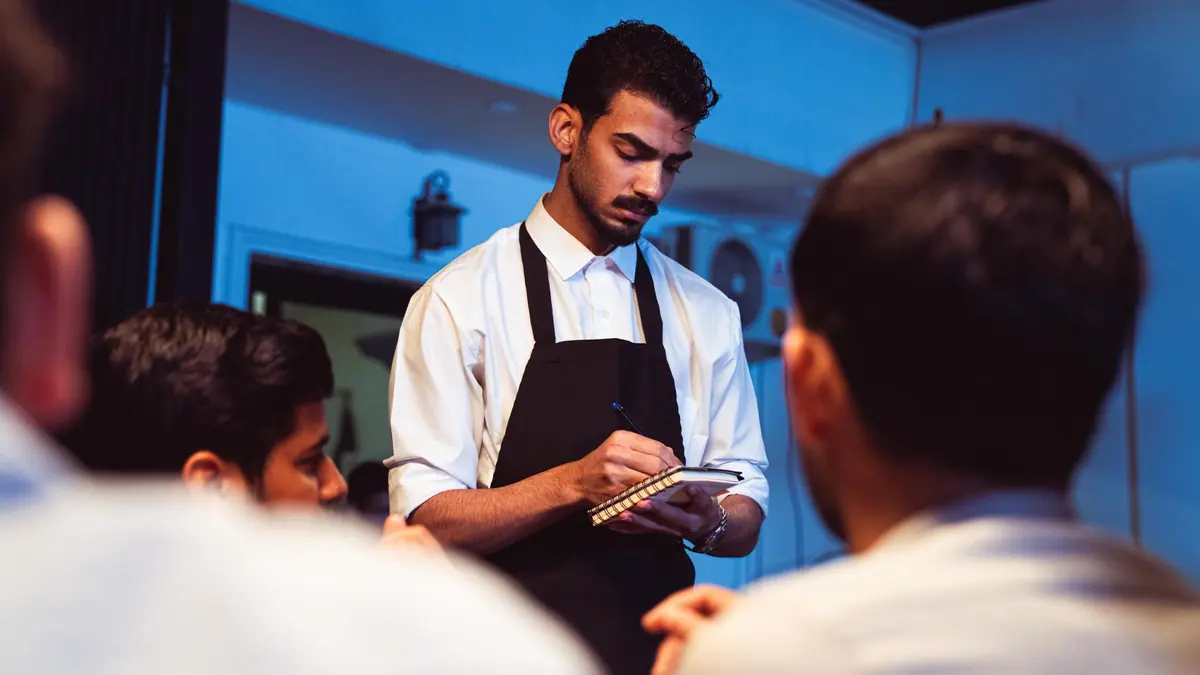 A host serving a dish to guests