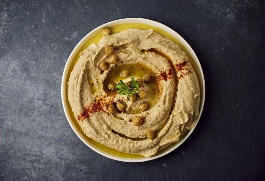 A plate of hummus finished with olive oil and paprika