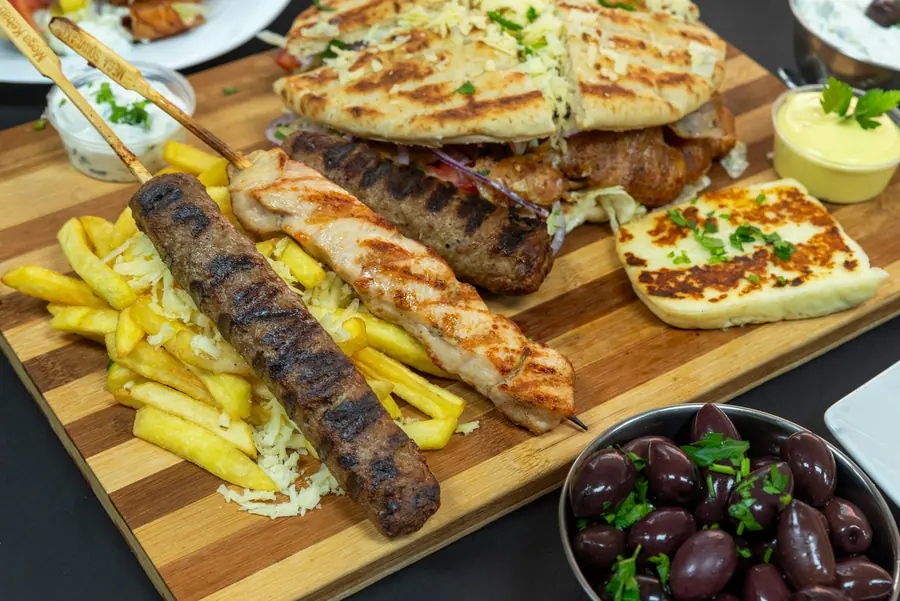 Seasoned ground meat shaped onto skewers and grilling