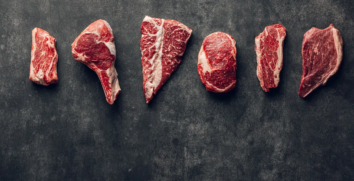 Raw cuts of meat displayed at a butcher's counter