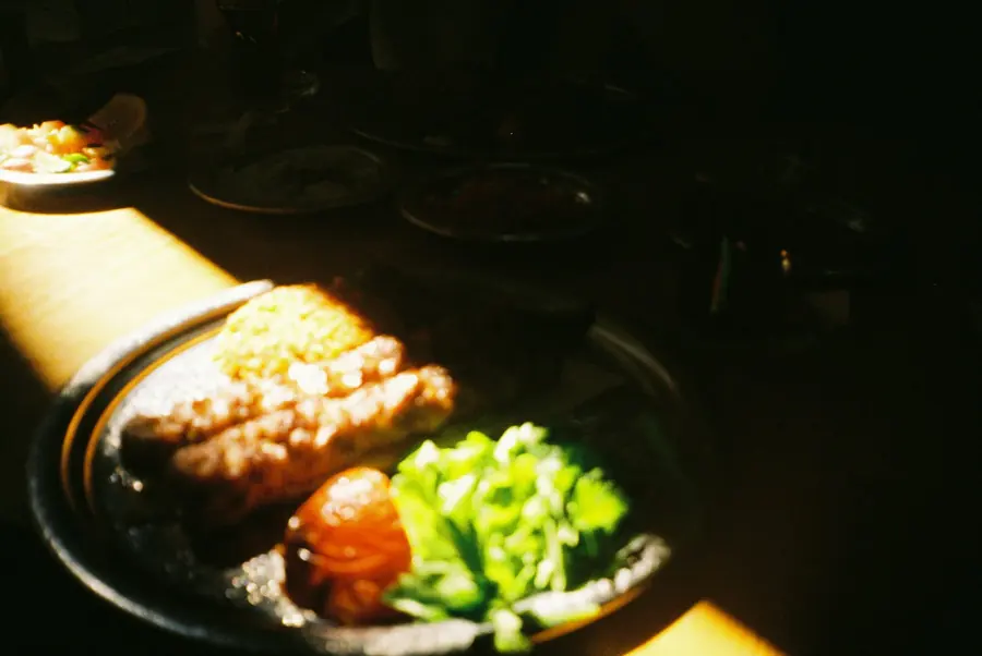 A rice plate served with grilled meat and fresh salad