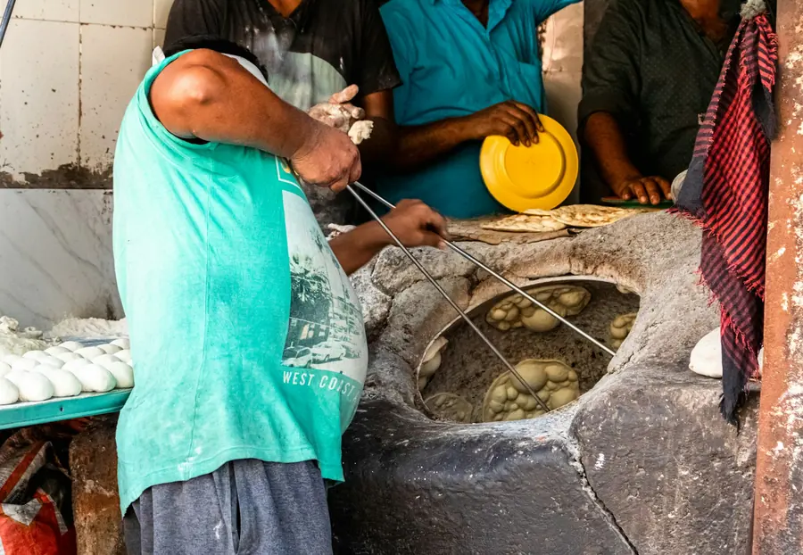Naan baking against the wall of a tandoor oven