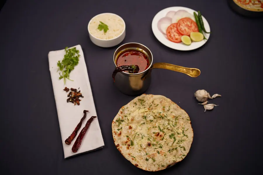 Naan served beside a bowl of curry