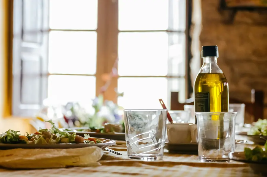 Olives and a jug of olive oil on a wooden surface