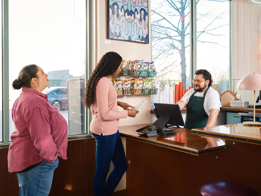 A customer placing an order at a restaurant counter