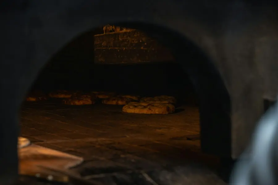 A pizza baking inside a stone oven