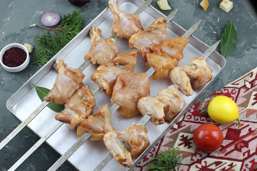 Raw chicken pieces on a preparation tray