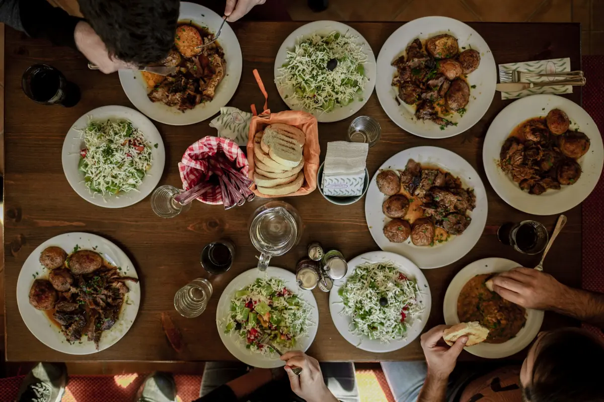 People sharing a table of Mediterranean dishes at a restaurant