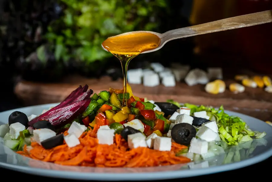 Dressing being poured over a salad