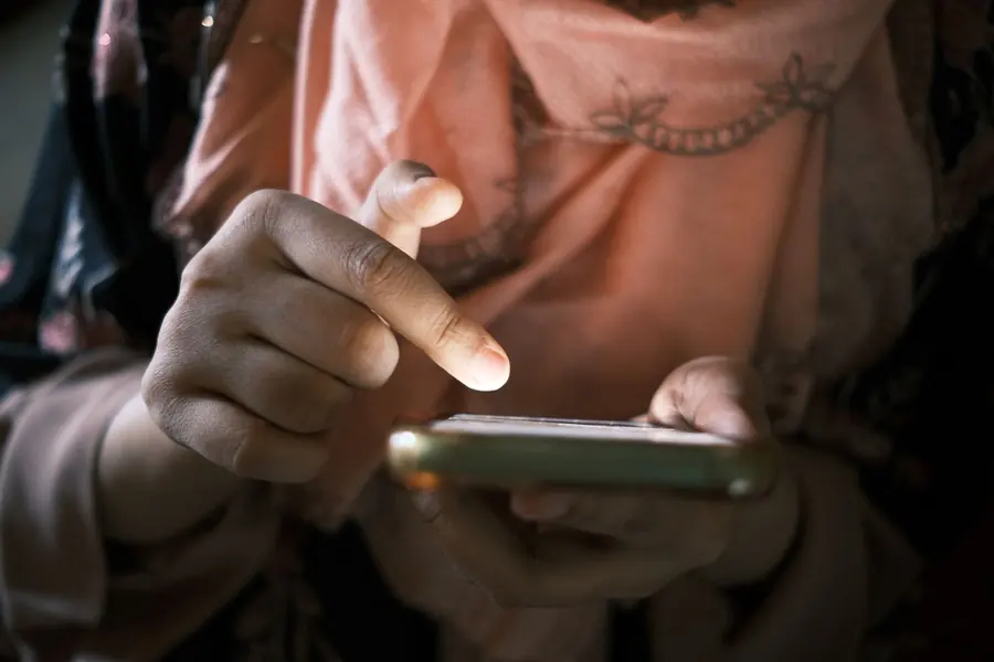 Someone scrolling a phone in a kitchen