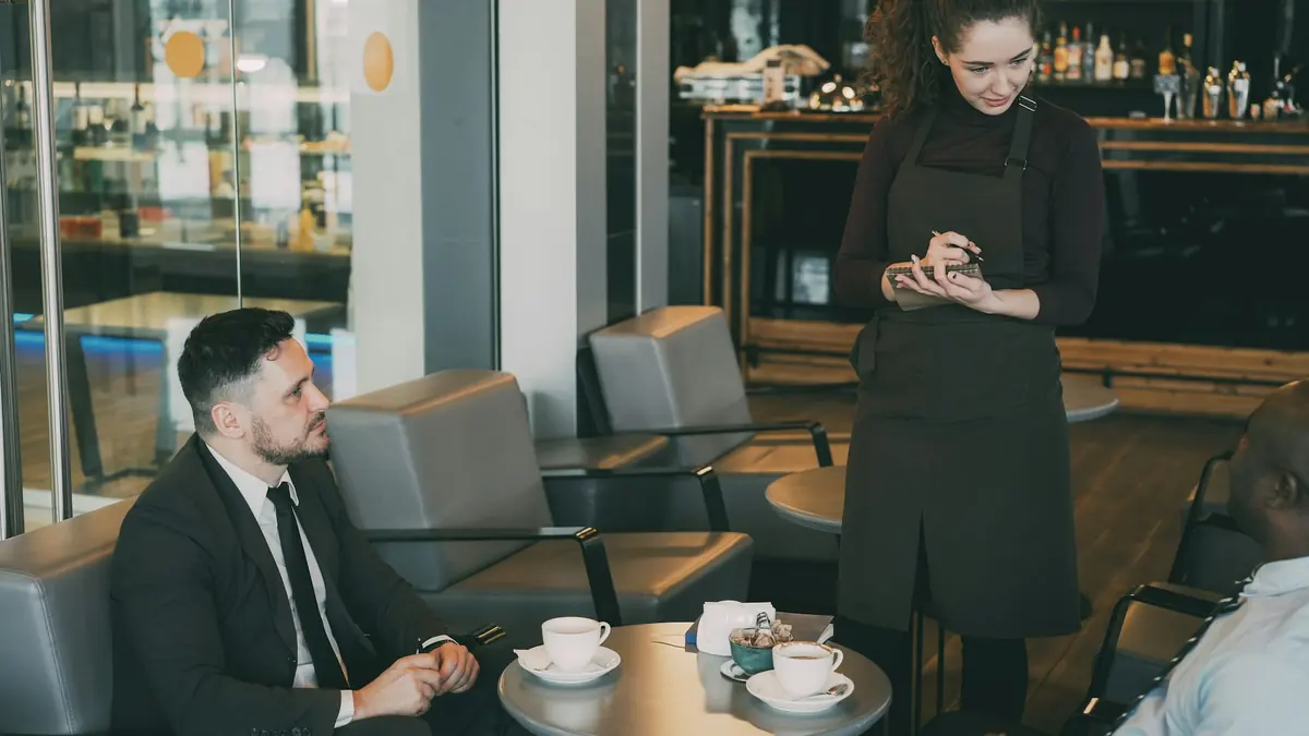 A server taking an order at a restaurant table