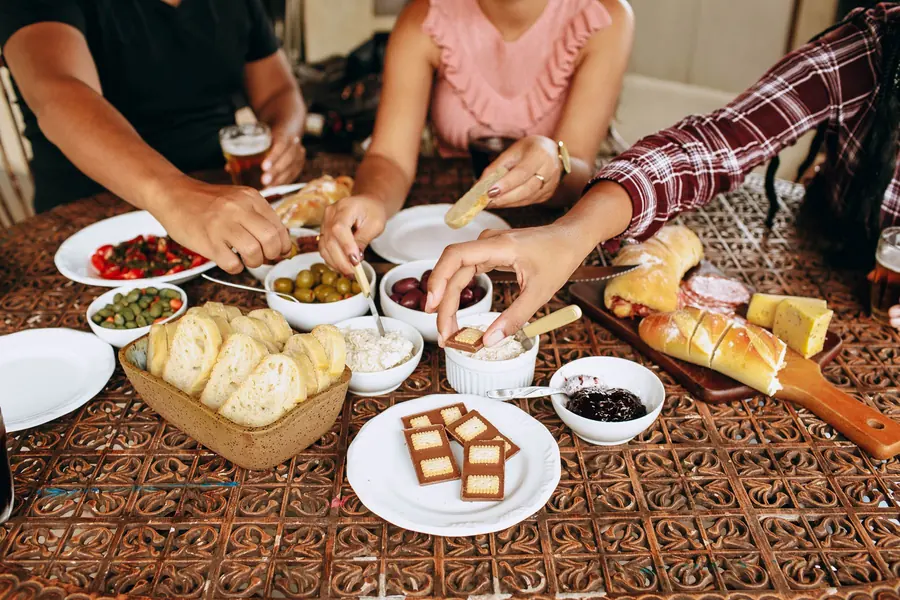 Hands reaching towards a shared platter