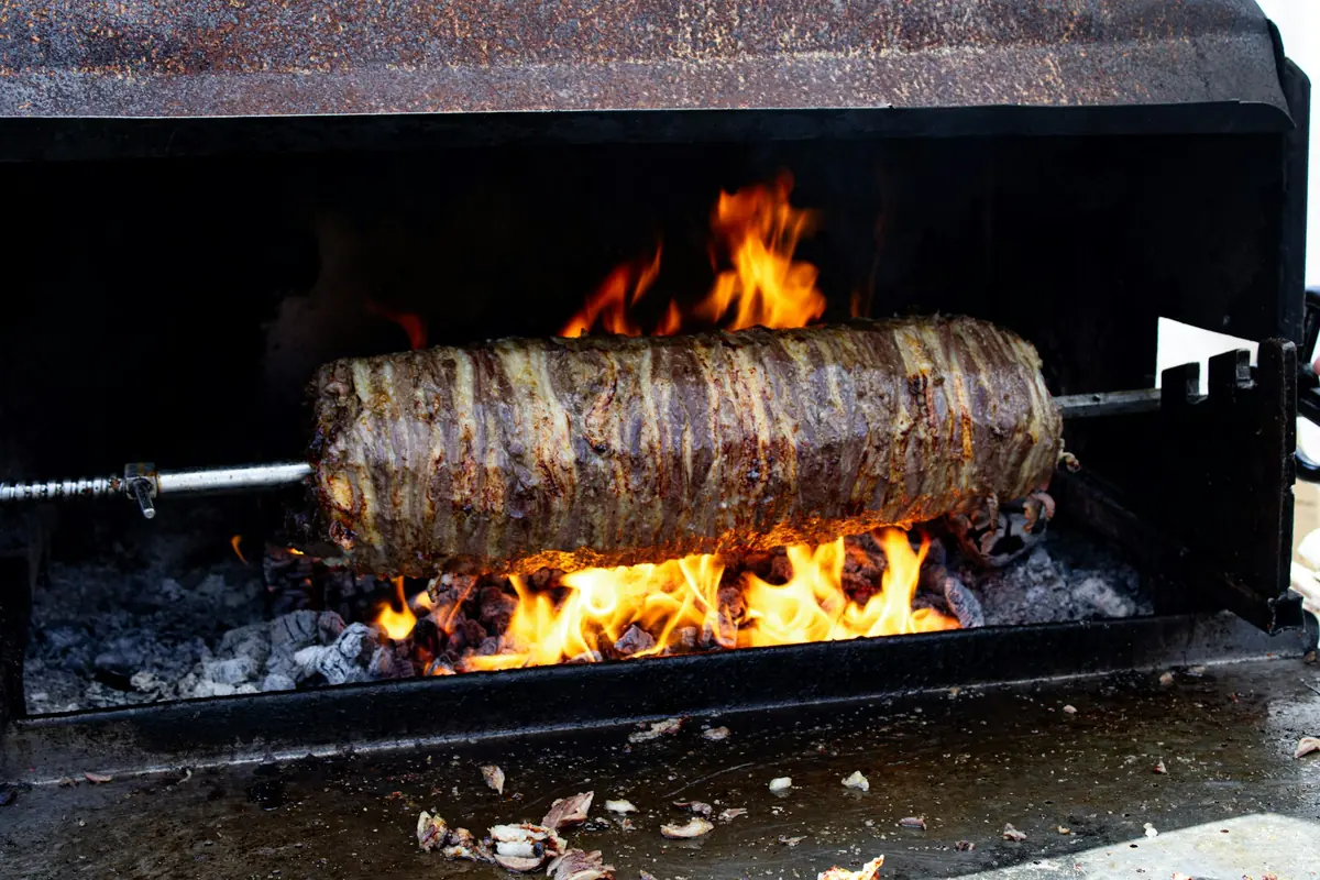 Marinated meat stacked on a vertical rotisserie and carved to order