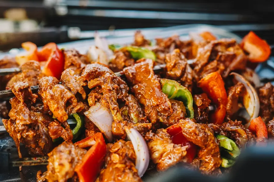 Cubes of marinated meat skewered with peppers and onion