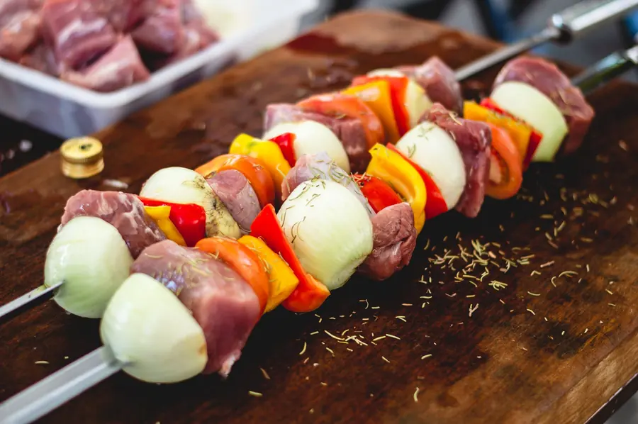 Small marinated skewers grilling over an open flame