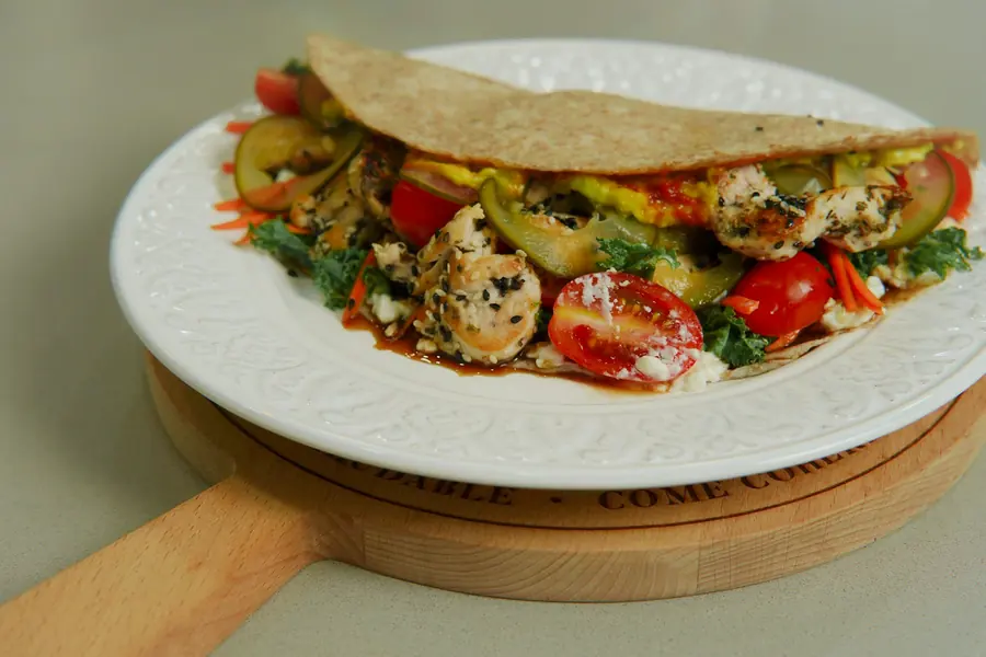 A pita wrap filled with vegetables and salad