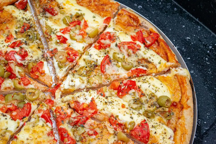 A slice of vegetable pizza with peppers and olives