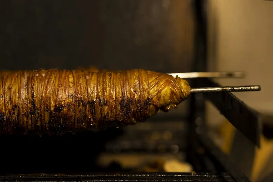 Meat turning on a vertical rotisserie