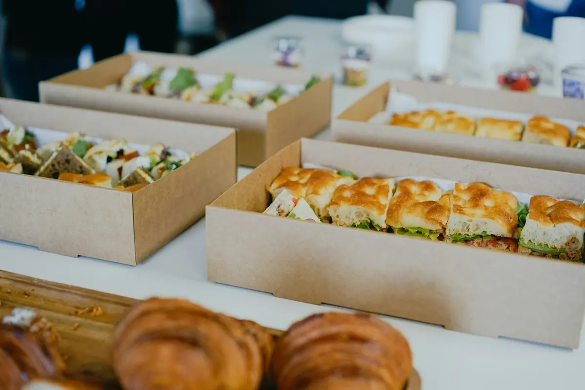 Colleagues serving themselves from a catered lunch in an office